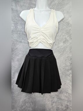 ALO Yoga Wild Thing Bra paired with a black pleated skirt